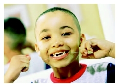 A boy flosses his teeth as part of a daily regimen for good oral hygiene. ( Joh Feingersh/Corbis.)