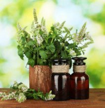 Essential oil and mint on green background close-up