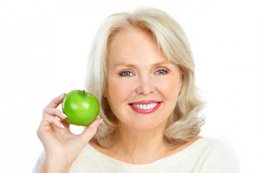 stock photo of older lady eating apple
